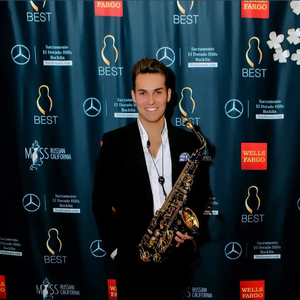 Live saxophone at an awards event with a sponsor wall