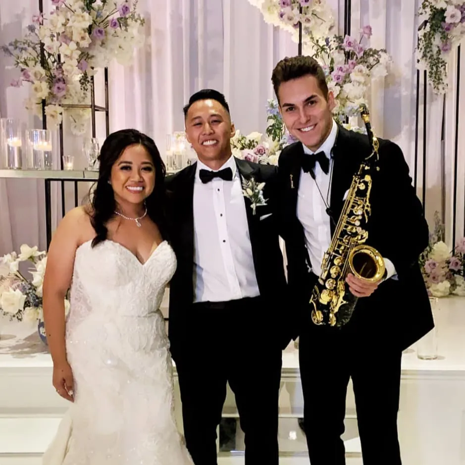 Newlyweds with DJ ART and his saxophone at their wedding